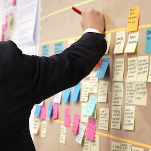 Person Contributing To Brainstorm With Sticky Notes